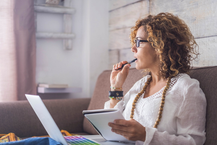 beautiful woman think and write notes on paper working on a laptop freedom from office at home. alternative lifestyle and place to work on. Nice life daily scene