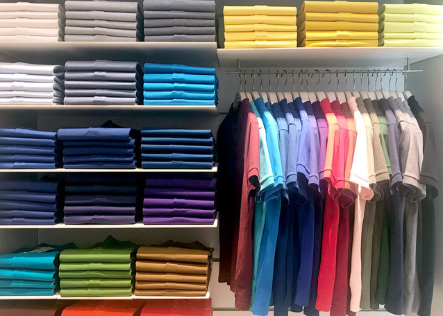 Multi color polo shirts on hanger and shelves for sale in store