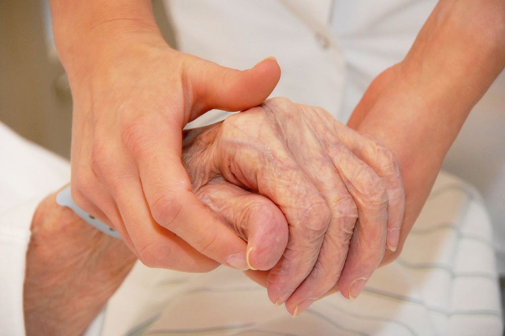 Alte Patientin reicht Pflegerin die Hand / Barmherzige Brüder Malteser Care warnt vor 'Systemkollaps' in der Pflege