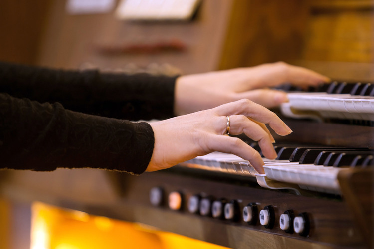 Hands of a woman playing the organ closeup