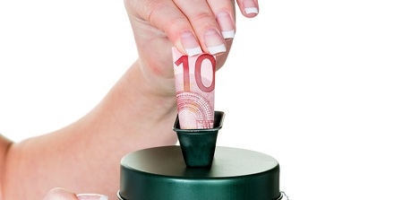 Eine Hand h?lt eine Spendensose. Es wird Geld gesammelt.