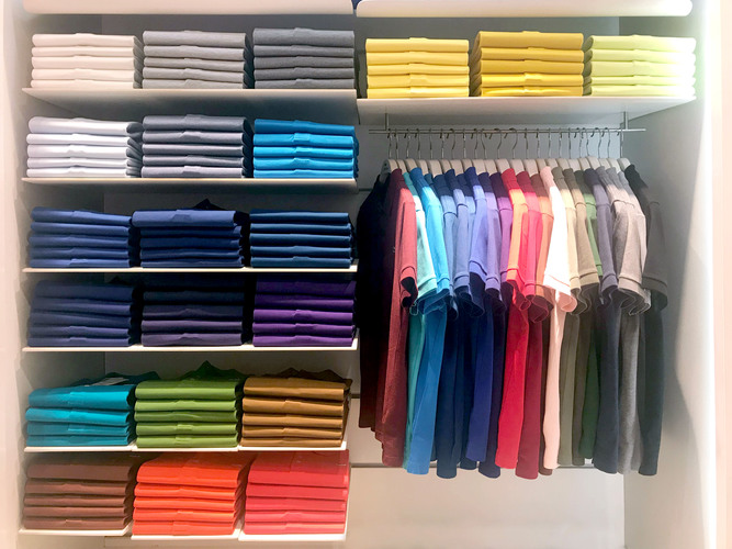 Multi color polo shirts on hanger and shelves for sale in store